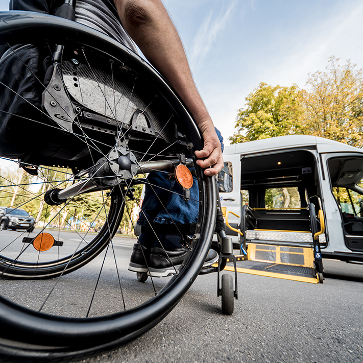 A wheelchair user approaches the lift on an ADA-compliant bus